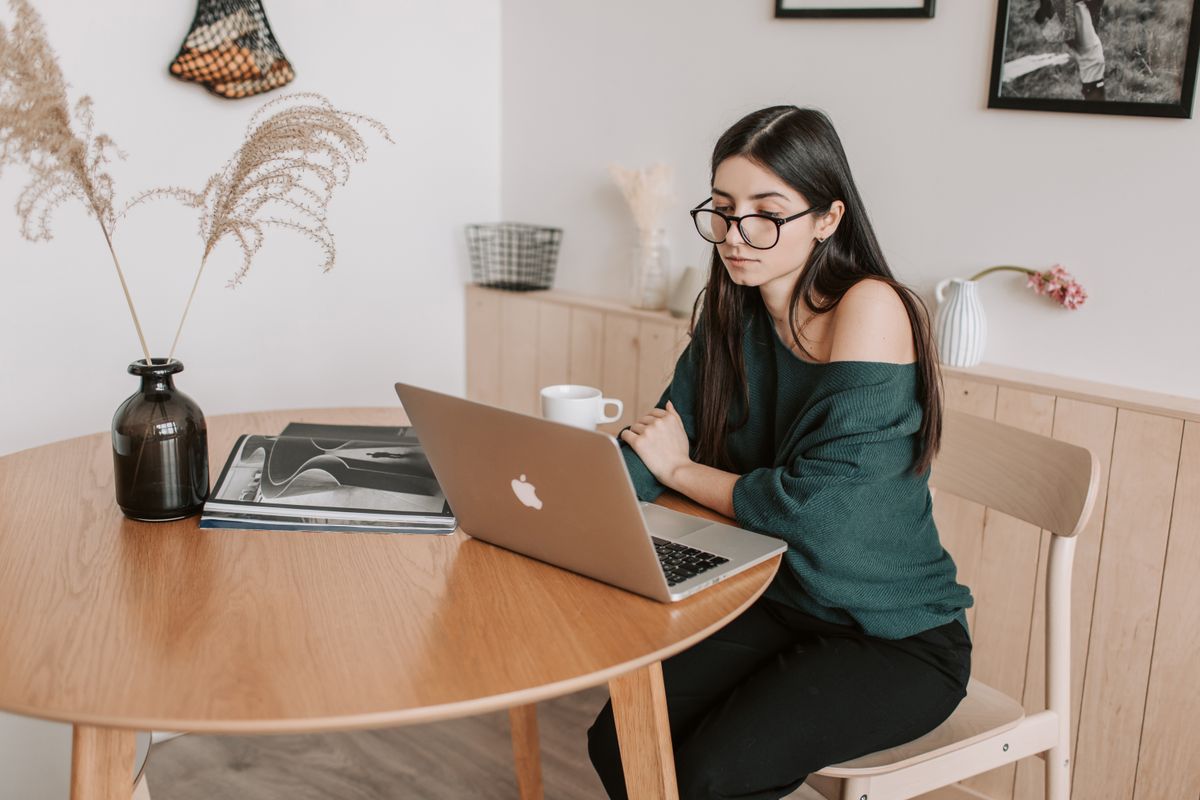 Freelancerin arbeitet konzentriert am Laptop in hellem, modernem Arbeitsbereich